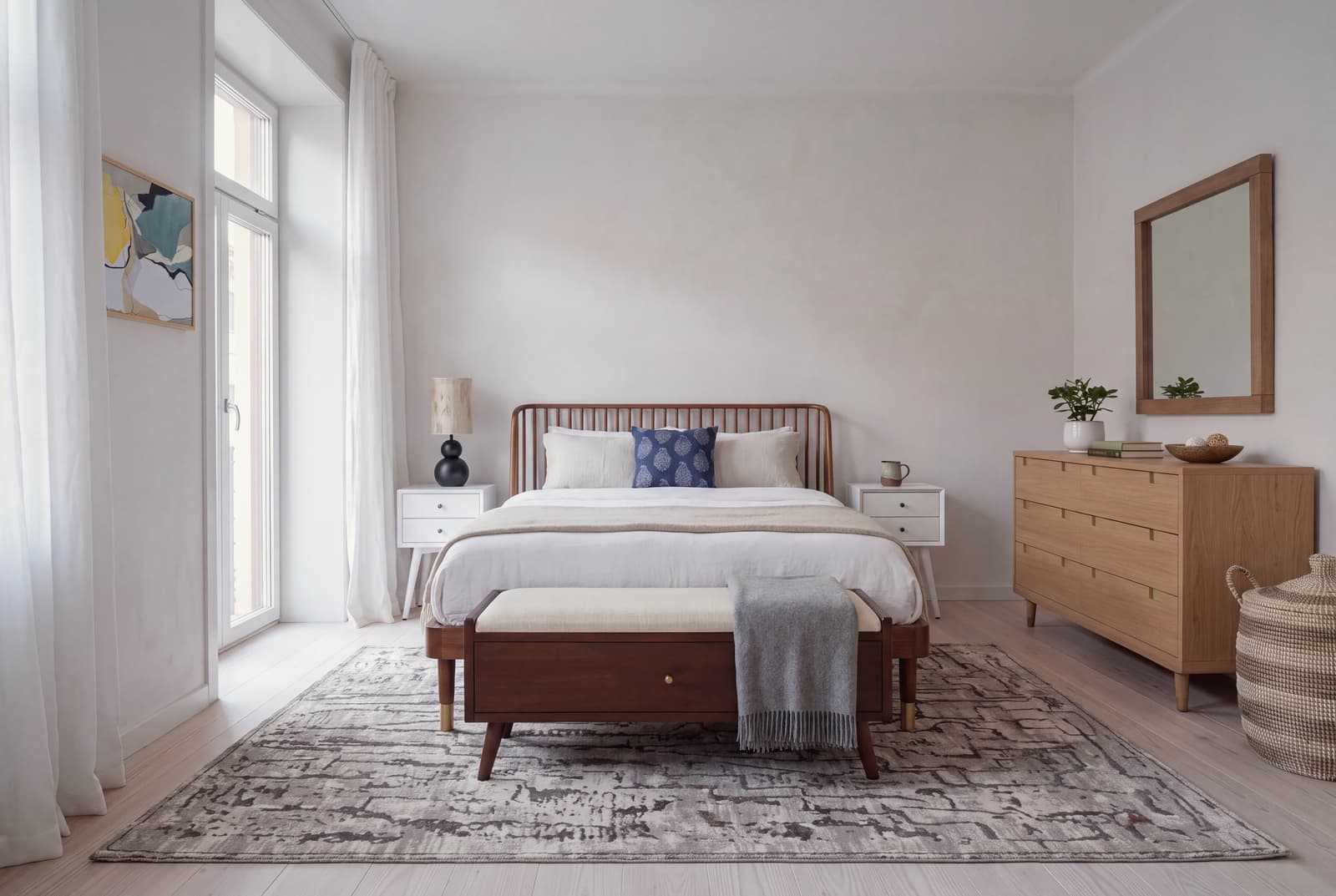 The bed sits low and the pieces around it stand on visible legs, so the floor reads as one continuous plane and a small room keeps its air.